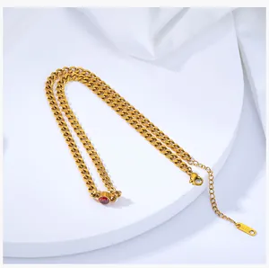 Macro view of gold-plated Cuban chain necklace featuring a red zircon centerpiece