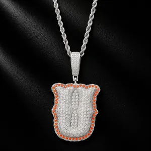 Close-up detail of iced out letter U pendant with orange border stones on silver rope chain