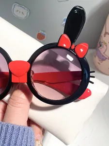 Close-up detail of cute black and red rabbit-themed cartoon sunglasses with UV protection