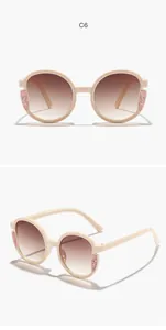 Dettaglio degli occhiali da sole rotondi per bambini con glitter rosa e lenti sfumate