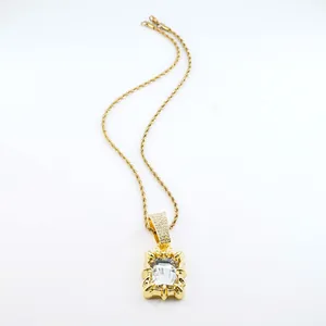 Close-up of golden rope chain necklace with a large clear rectangular gemstone pendant