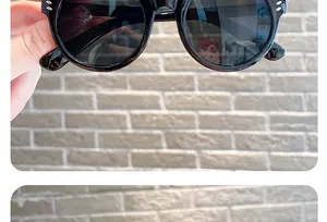 Detailed view of fashionable black round children sunglasses with silver rivet accents