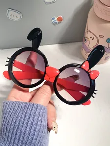 Close-up of cute children's bunny-shaped sunglasses with round frames and red bow details.