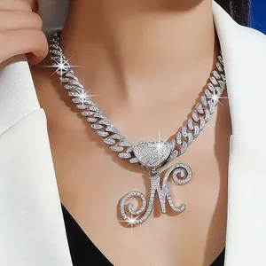Iced out Cuban link chain necklace with heart and cursive letter M pendant