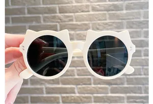 Close-up of cute creamy white cat-ear children's sunglasses for UV protection