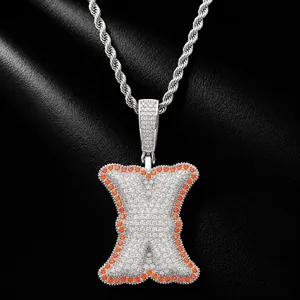 Close-up of silver-tone letter X pendant with white and orange zircon stones.