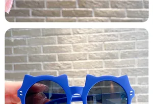 Detailed close-up of blue cat-ear children's sunglasses frame with cute white dots