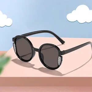 Eleganti occhiali da sole rotondi per bambini con montatura nera e glitter argento