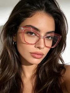 Close-up detail of stylish cat-eye glasses with red inner rim on a female model