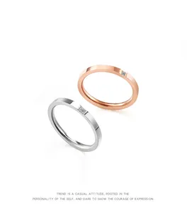Detailopname van minimalistische titaniumstalen ringen in zilver en roségoud met diamant.