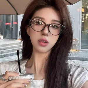 Dettaglio degli occhiali cat-eye marrone scuro indossati da una modella al caffè