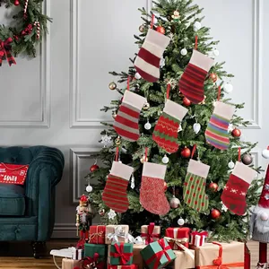 Set of 9 colorful knitted Christmas stockings hanging on a festive Christmas tree.