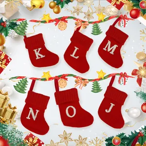 Rode gebreide kerstsokken met fonkelende zilveren geborduurde letters decor.