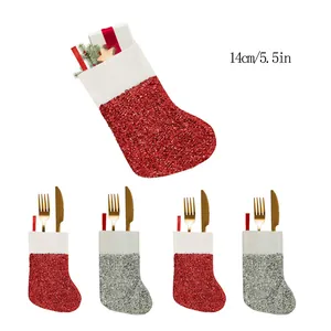 Mini glitter Christmas stockings used as cutlery holders for festive table decorations