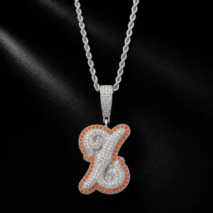 Macro view of silver-tone iced-out hip-hop pendant with orange and white zircons.