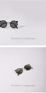 Macro view of children's metal sunglasses featuring cute cartoon cat ears