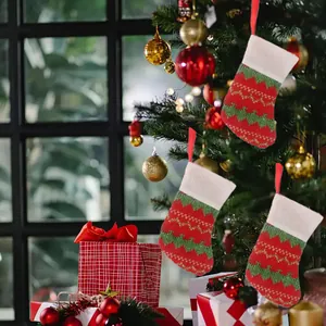 Detailed view of three mini knitted Christmas stockings hanging as festive tree ornaments