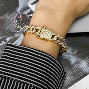 Detailopname van een goudkleurige Cuban link armband met fonkelende strass-steentjes