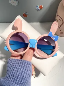 Close-up of pink children's sunglasses with cute blue bunny ears and bow detailing