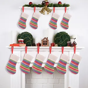 Detailed view of colorful striped knitted Christmas stockings hanging on a fireplace