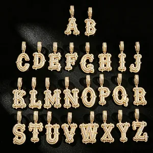 Detailed view of 26 gold-plated iced out alphabet pendants with thorn edges for hip hop jewelry.
