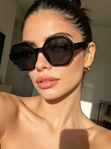 Close-up detail of stylish retro black hexagonal sunglasses worn by a female model