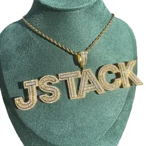 Detailed view of gold iced-out JSTACK letter pendant with sparkling zircons