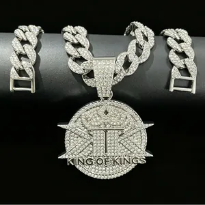 Detailed macro shot of iced out King of Kings pendant on a silver Cuban link chain jewelry
