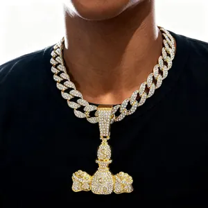 Gros plan sur une chaîne cubaine dorée avec un pendentif en forme de sac d'argent pour homme