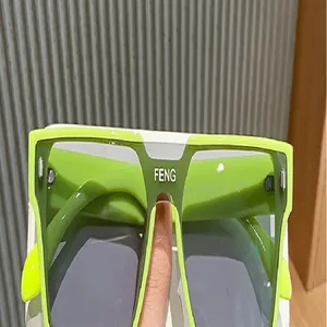 Vista detallada de gafas de sol punk verde neón cuadradas con el logotipo de FENG.