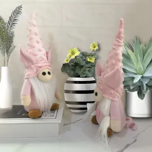 Close-up of pink Valentine's Day plush gnomes with pig ears on a white book stand