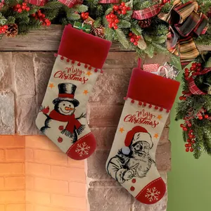Detailansicht großer Weihnachtsstrümpfe aus Sackleinen mit Weihnachtsmann am Kaminofen