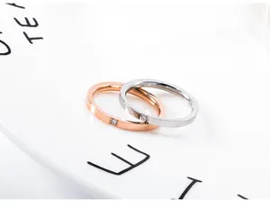 Close-up van minimalistische titaniumstalen ringen in roségoud en zilver met diamant.