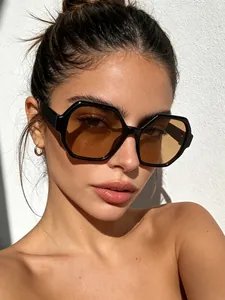 Detail view of stylish retro polygon sunglasses with black frames and brown lenses