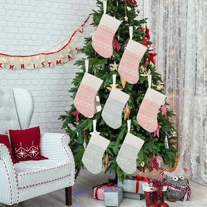 Set of pink and blue knitted Christmas stockings hung on tree for festive decor