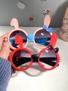 Close-up of cute pink and red bunny-shaped sunglasses for kids with bow details.