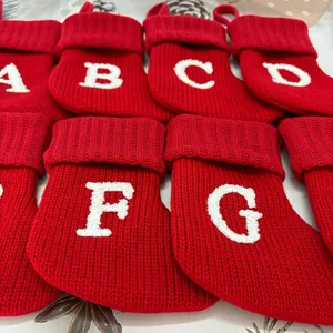 Detailoverzicht van rode gebreide kerstsokken met wit geborduurde alfabetletters