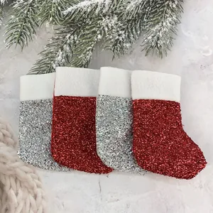 Close-up of four glittery mini Christmas stockings used as ornaments or cutlery holders