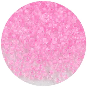 Vista macro detallada de cuentas de vidrio rosa transparente para joyería artesanal DIY.