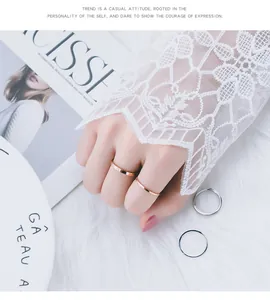 Close-up van minimalistische titaniumstalen ringen in roségoud en zilver met kanten mouw