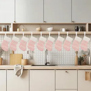 Set of ten pink knitted Christmas stockings hanging in a modern kitchen setting