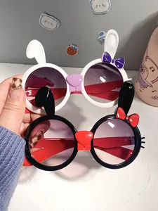 Detail view of cute white and black rabbit children's sunglasses with decorative bows.