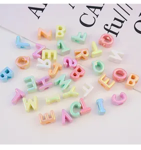 Primer plano de cuentas de letras de acrílico con baño UV de colores para bricolaje.