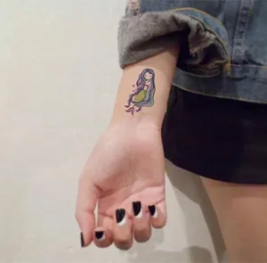 Detailed view of a cute cartoon mermaid temporary tattoo sticker for kids on a wrist