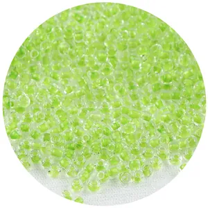 Detalle macro de cuentas de vidrio transparentes con centro verde para joyería DIY