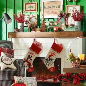 Nahaufnahme von zwei rustikalen Weihnachtsstrümpfen mit Weihnachtsmann- und Schneemann-Motiv