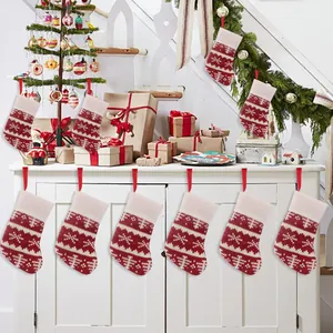 Close-up of red and white knitted Christmas stockings hanging on a white cabinet