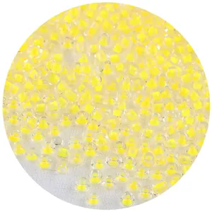 Vista macro detallada de pequeñas cuentas de cristal con núcleo amarillo para joyería DIY.