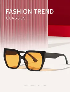 Detailed view of trendy square cat eye sunglasses with orange lenses and thick black frames.