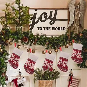 Detailed view of five red and white knitted Christmas stockings hanging as festive decor.